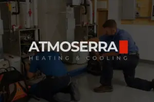 Two technicians work on heating and cooling systems in a utility room, with the logo "ATMOSERRA Heating & Cooling" overlaying the image.