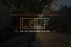 Logo of The Lacy Employment Law Firm superimposed over an image of a quiet city street at twilight.